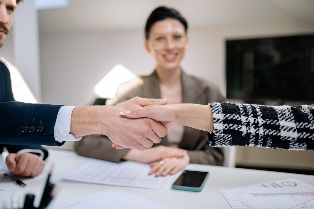 Stretta di mano durante un colloquio di lavoro tra candidato e azienda in Italia